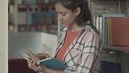 Free stock video - Pretty girl reading a book in the library