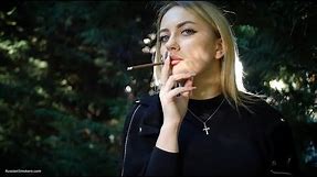 Alina is smoking brown 120mm cigarette in the park