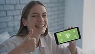 Free stock video - Portrait of a pretty young woman holding a phone with mockup green screen