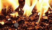 Close-up view of black reflective fire glass burning