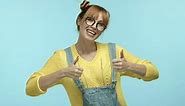 Funny Hipster Girl in Glasses and Overalls Showing Thumbsup Gesture Saying Yes and Dancing Happy