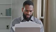 Overworked Millennial Black Male Office Worker Stressed By Paperwork