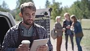 Free stock video - Coffee truck worker while using a tablet and drinking coffee, group of people talk and drink coffee in the background