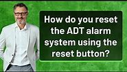 How do you reset the ADT alarm system using the reset button?
