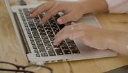Free stock video - Closeup shot of young female hands typing on laptop keyboard