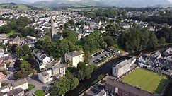 Cockermouth town high street, Lake District Cumbria UK pull back drone reveal aerial footage 4K