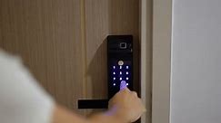 Hand press PIN number for smart digital door lock while open or close the door at home or apartment. NFC Technology, Fingerprint scan, keycard, smartphone and contactless lifestyle concepts