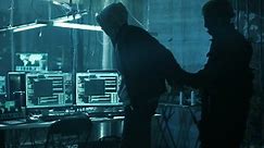 Special Forces Cybersecurity Agent Arrests, Handcuffs and Takes Away Very Dangerous Hacker. In the Background Hacker's Lair Full Monitors and Hacking Devices.Shot on RED EPIC-W 8K Helium Cinema Camera