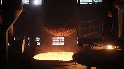 Railway Car Manufacturing Plant. A Huge Metal Boiler with chains is being Lowered into the Industrial Furnace that is covered with orange fire Residue. Production Process. Slow-motion. Wide Shot.