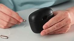 Patient charging hearing aid in special portable Smart Charger with built-in power bank. Case in man hands keeps hearing aids dry and safe