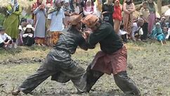 Indonesian martial artists demonstrate ancient silat fighting skills in muddy rice field