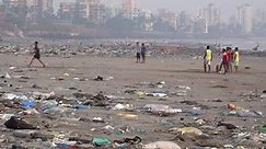 MUMBAI, INDIA - NOV 17: Teenage Indians play game of cricket among plastic garbage and other pollution at Versova Beach on November 17, 2017 in Mumbai, India