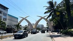 Mombasa , Kenya - 05 20 2023: Cars driving through Mombasa city in Kenya with famous Tusk landmark