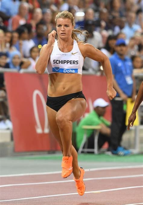 a woman running on a track in front of a crowd