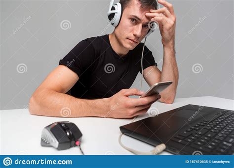 Gamer Wearing Headphones Checking Smartphone While Playing