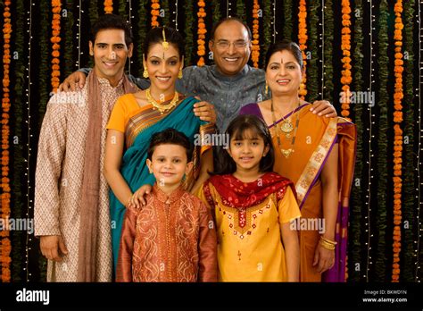 generation indian family standing wearing traditional dress stock