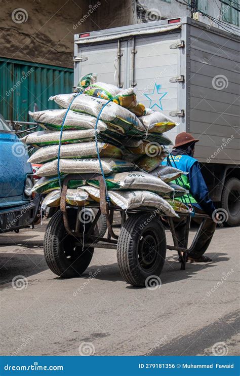 man worker carrying goods   trolley carrying goods   traditional market editorial photo