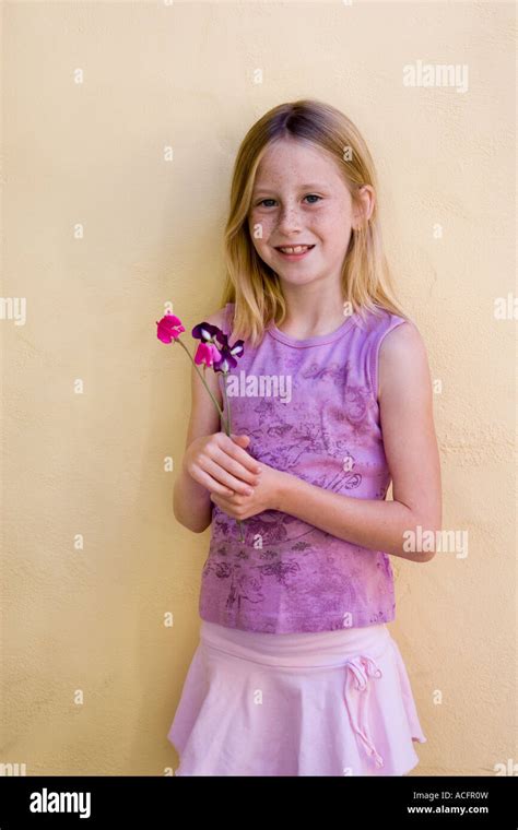 porträt von blonden mädchen 9 jahre in rosa und lila outfit mit lila