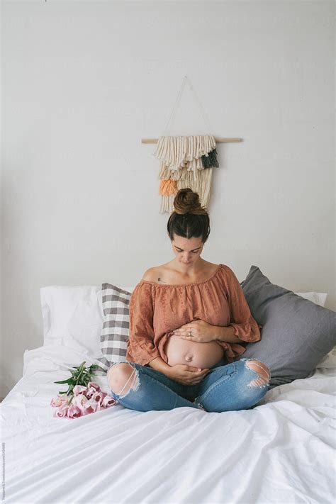 pregnancy photos on a bed by stocksy contributor pink house organics