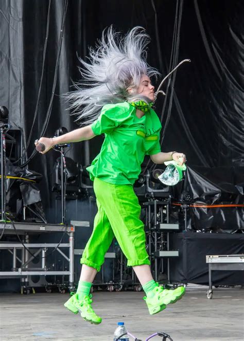 woman  white hair  green pants performing  stage   outdoor  festival