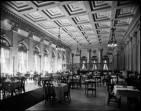 An Old Black And White Photo Of A Dining Room With Tables Chairs And