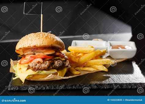 gran hamburguesa de queso  papas fritas aisladas en fondo negro hamburguesa  patata de