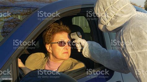 close up woman gets her temperature measured before crossing the