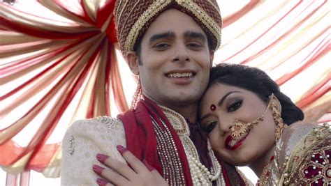 pan shot of indian bride and groom in traditional wedding dress posing