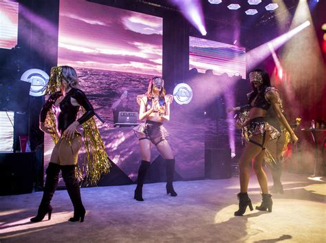 dancers perform at a booth for adj lighting equipment during the