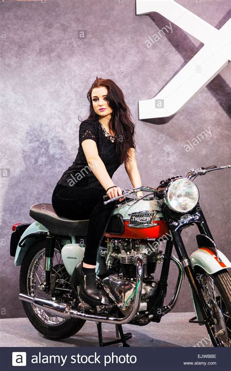 pretty girl brunette posing on triumph motorbike