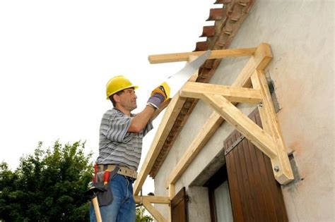 man working   side   building  holding  hammer  nailing