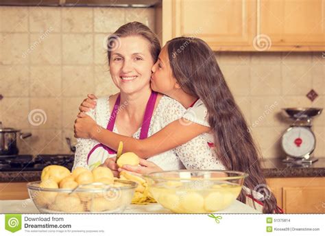happy smiling mother and daughter cooking dinner