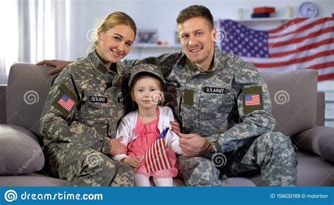 Happy American Soldiers Couple And Daughter With Us Flag