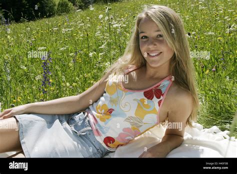 flower meadow teenagers girl lie sit happy spring leisure stock