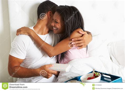 man bringing woman breakfast in bed on celebration day