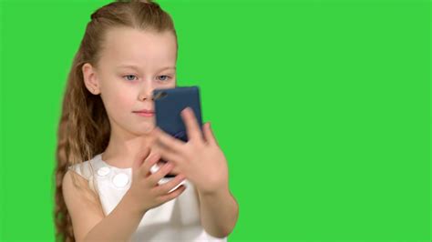 little cute girl smile and taking selfie on a green screen chroma key