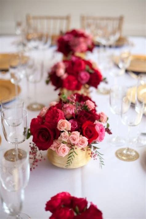 picture of red and pink floral centerpieces with berries in gold vases are amazing to add color