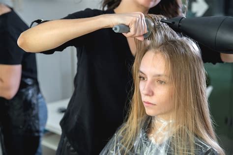 Premium Photo Close Up Of Hairdressers Hands Drying Long Blond Hair