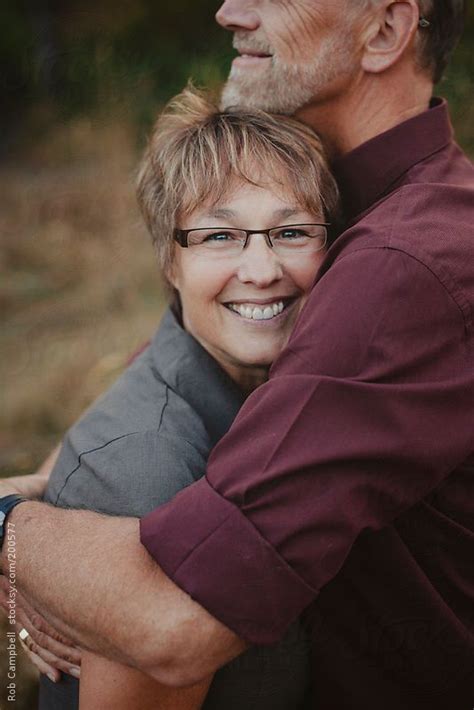 Middle Aged Woman Enjoying A Hug From Her Husband By Stocksy