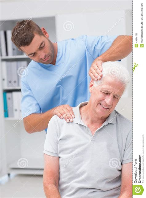 therapist giving massage to senior male patient stock image image of