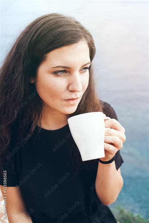 Beautiful Young Caucasian Woman Is Drinking Coffee On A Balcony With