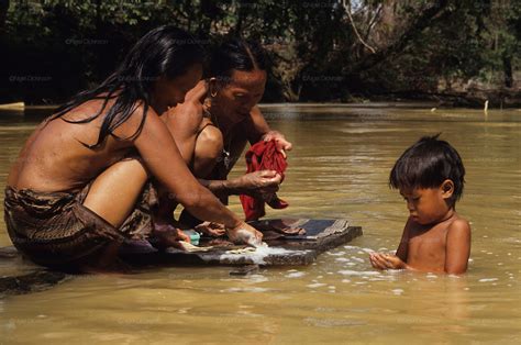 Indigenous Dayak Washing In River Tropical Rainforest