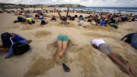g20 protesters bury heads in the sand on bondi beach bbc news