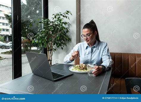 jovem profissional ocupada usando terno usando laptop sentado  restaurante gerenciador famoso