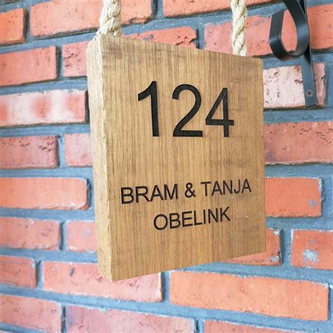 houten voordeur hangbord met huisnummer en naamnamen