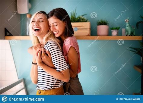 cheerful lesbians embrace passioantely and have fun together stock