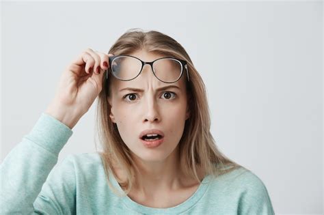 astonished blonde female model with spectacles keeps mouth widely