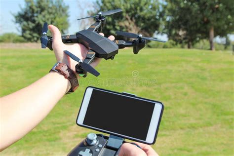 young man  remote control cell phone hold drone sunny green stock image image  control