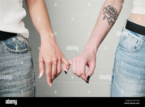 Close Up Of Unrecognizable Lesbians Holding Pinkie Fingers Together As