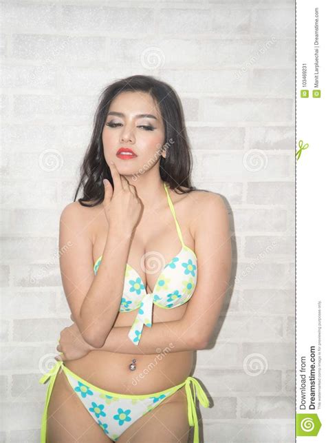 vrij aziatische vrouw in het sexy bikini stellen die zich voor van de